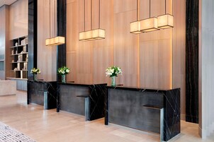 A reception area with a marble counter, black marble base, and three pendant lights.