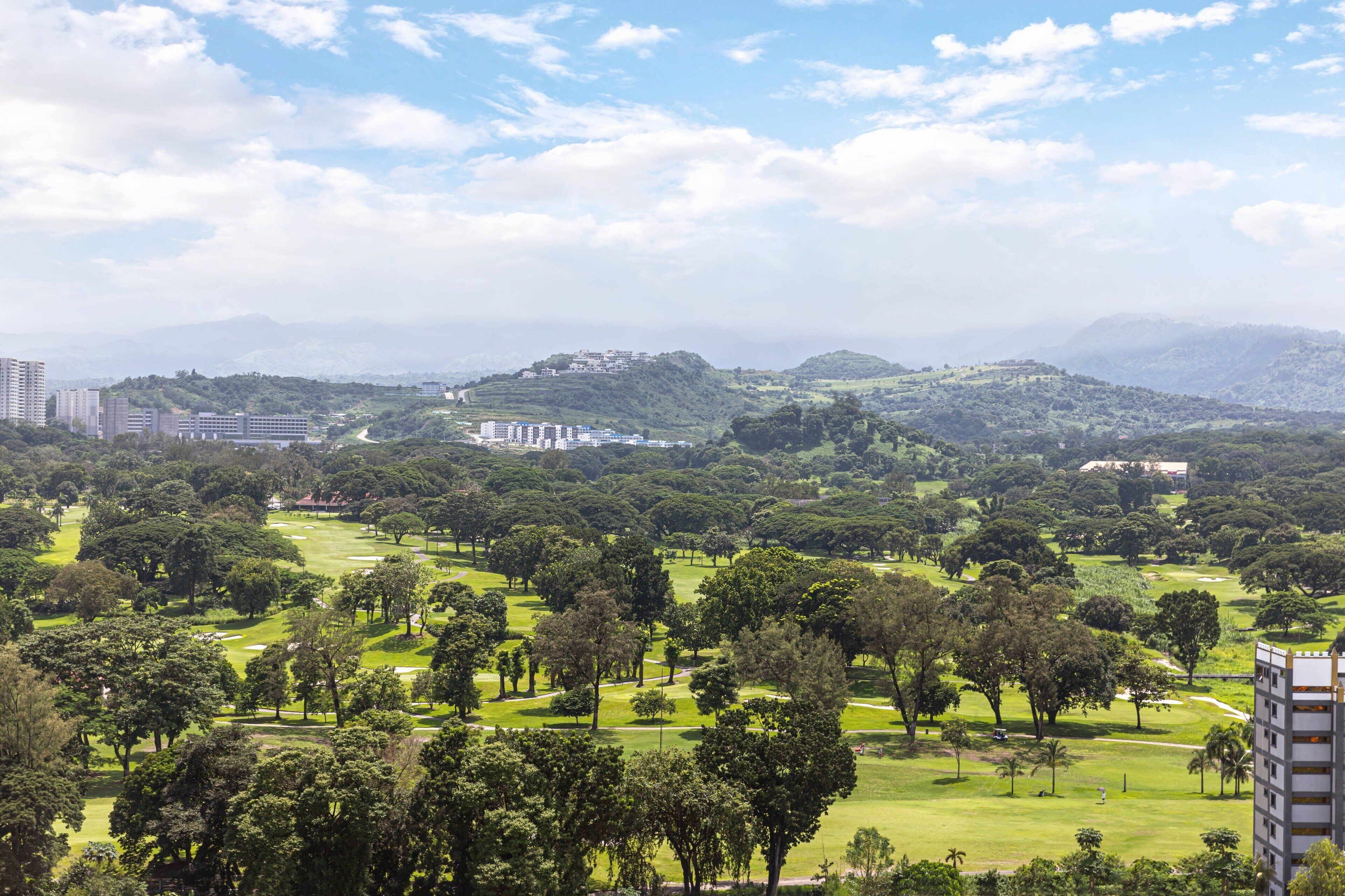 Un campo de golf con edificios al fondo.