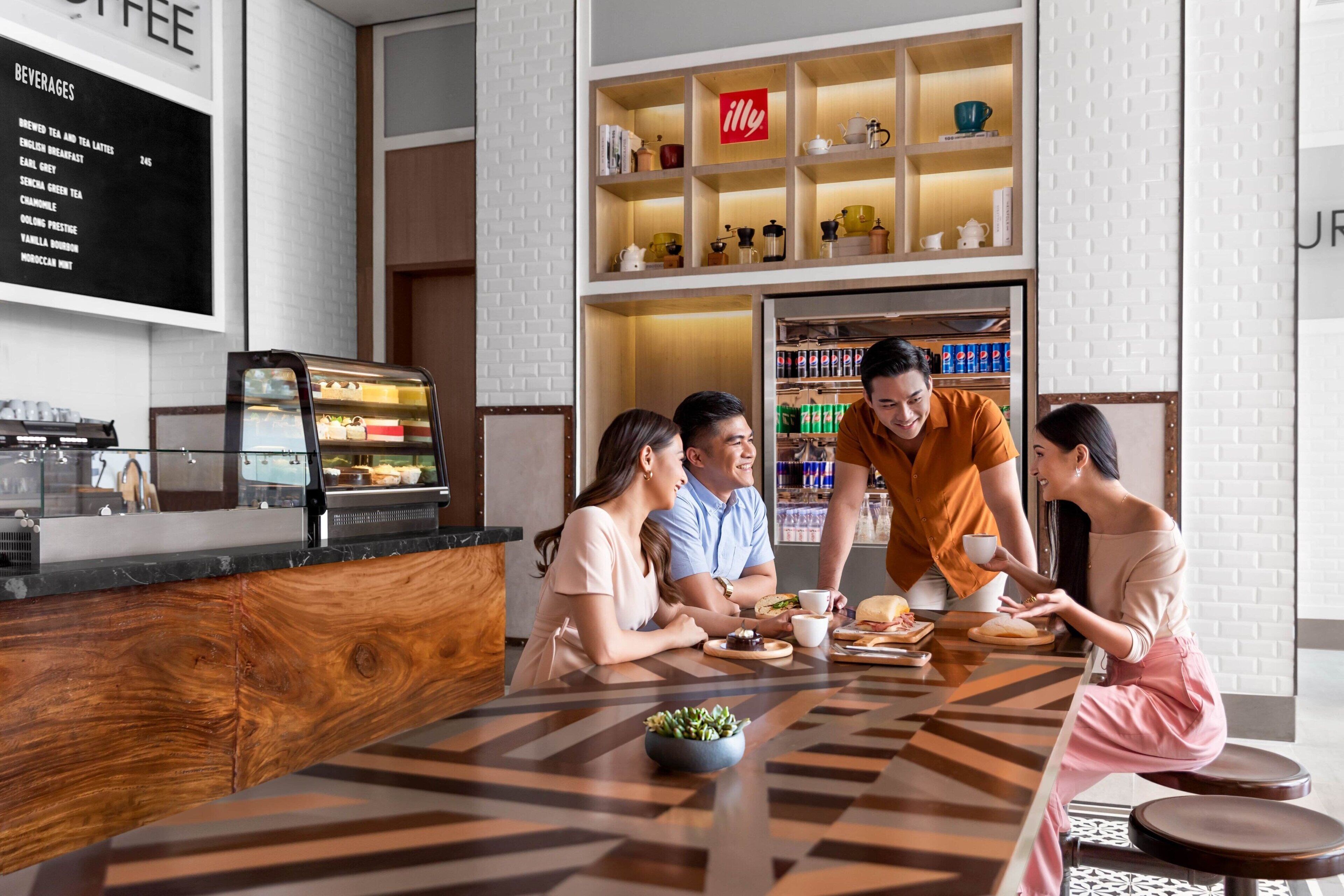 A modern cafe with a wooden counter, a menu board, and a shelf with various items.