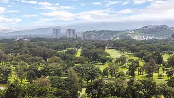 Campo de golf con vistas a edificios al fondo.