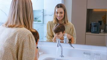 Un baño con pared de mármol, un lavabo y toallas.