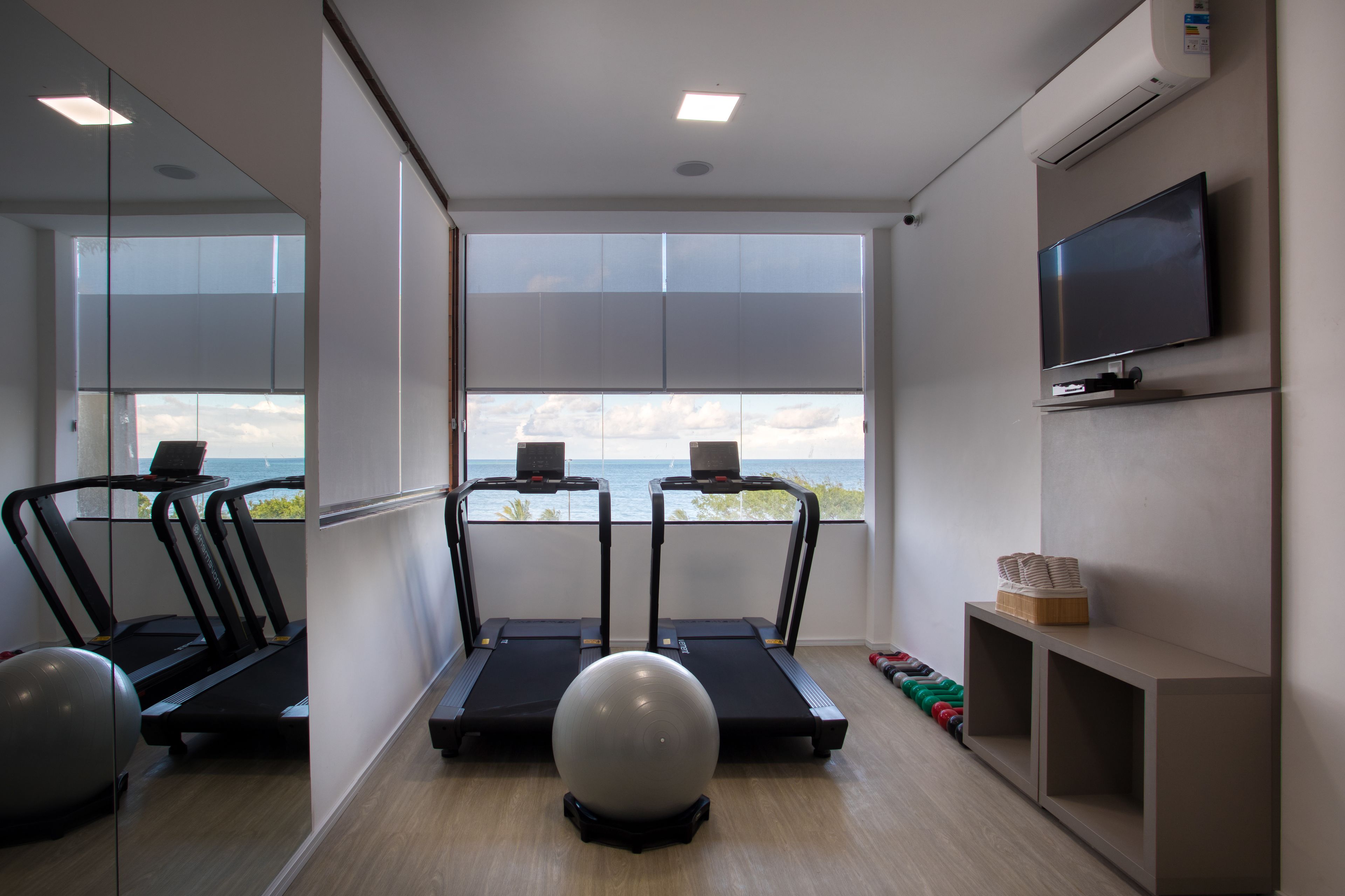 A gym with treadmills, a stationary bike, and exercise balls.