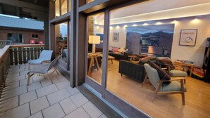 Uma sala de estar moderna com lareira, assentos confortáveis e grandes janelas com vista panorâmica.