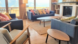 Uma sala de estar moderna com sofá, cadeiras e lareira.
