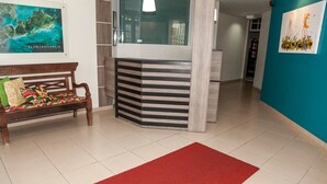 Un área de recepción con un banco de madera, una alfombra roja y un mapa de Florianópolis en la pared.