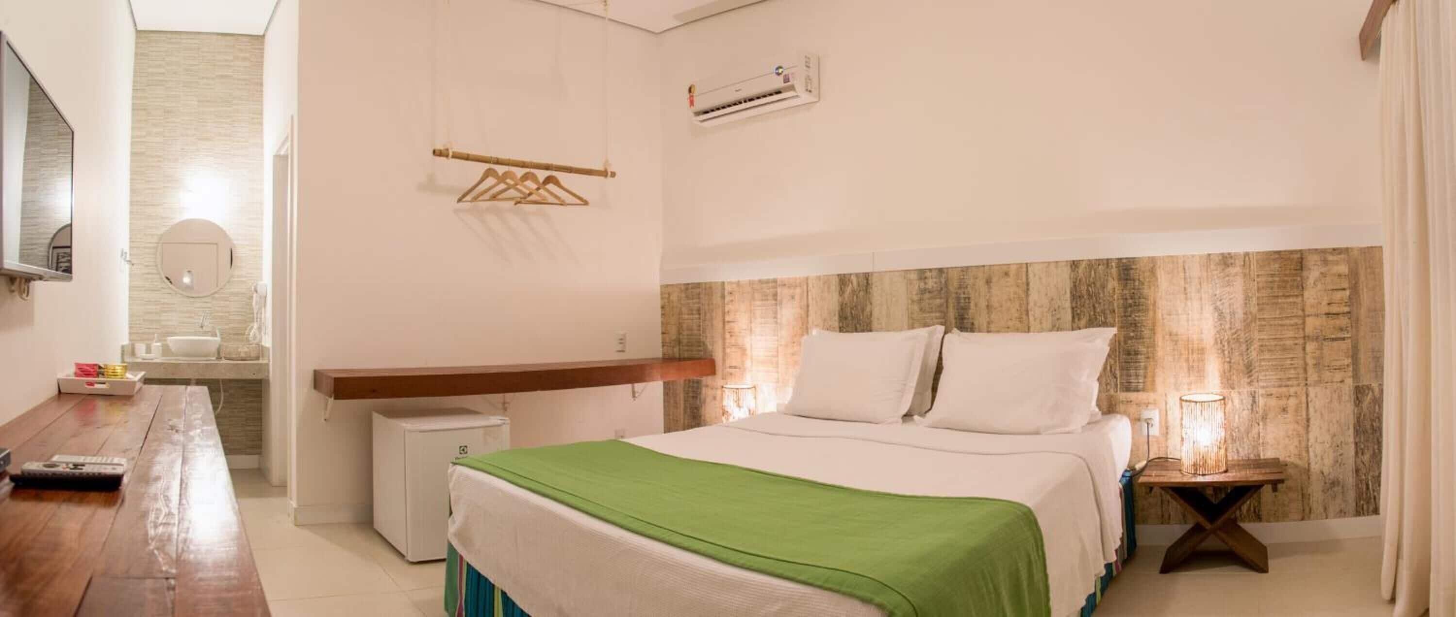 A bedroom with a bed, bedside table, and a small desk with a chair.