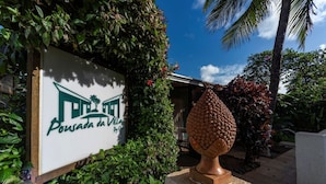 A sign for 'Pousada da Villa' with a stone urn in front. - Pousada da Villa (Fernando de Noronha)