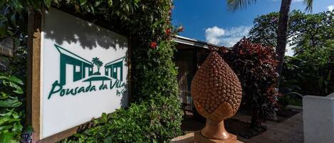 Una señal para 'Pousada da Villa' con una urna de piedra al frente.