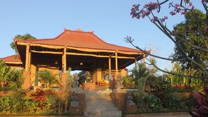 A traditional building with a tiled roof, a covered porch, and a staircase leading to the entrance.