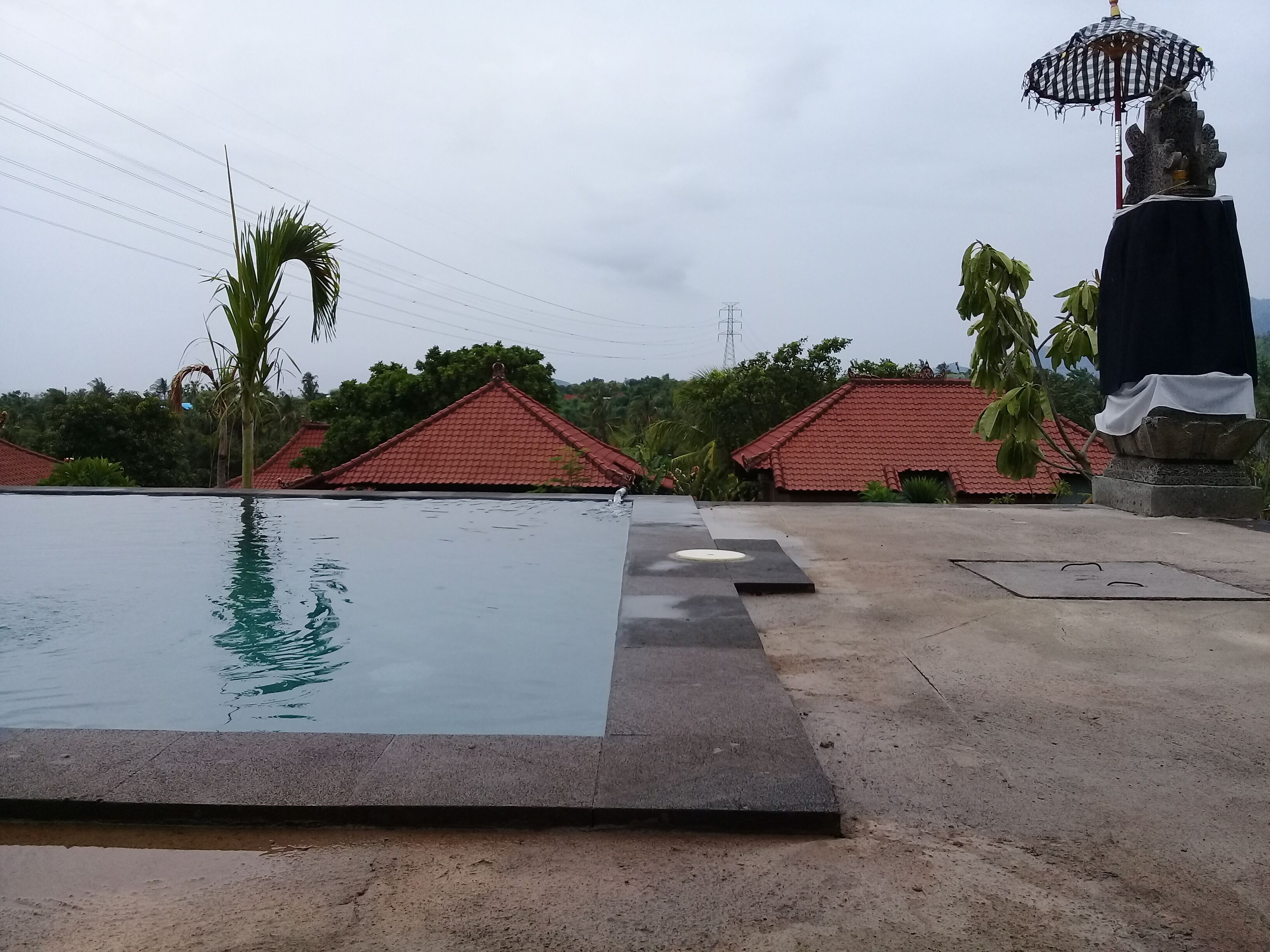 A swimming pool with a red-roofed building in the background.
