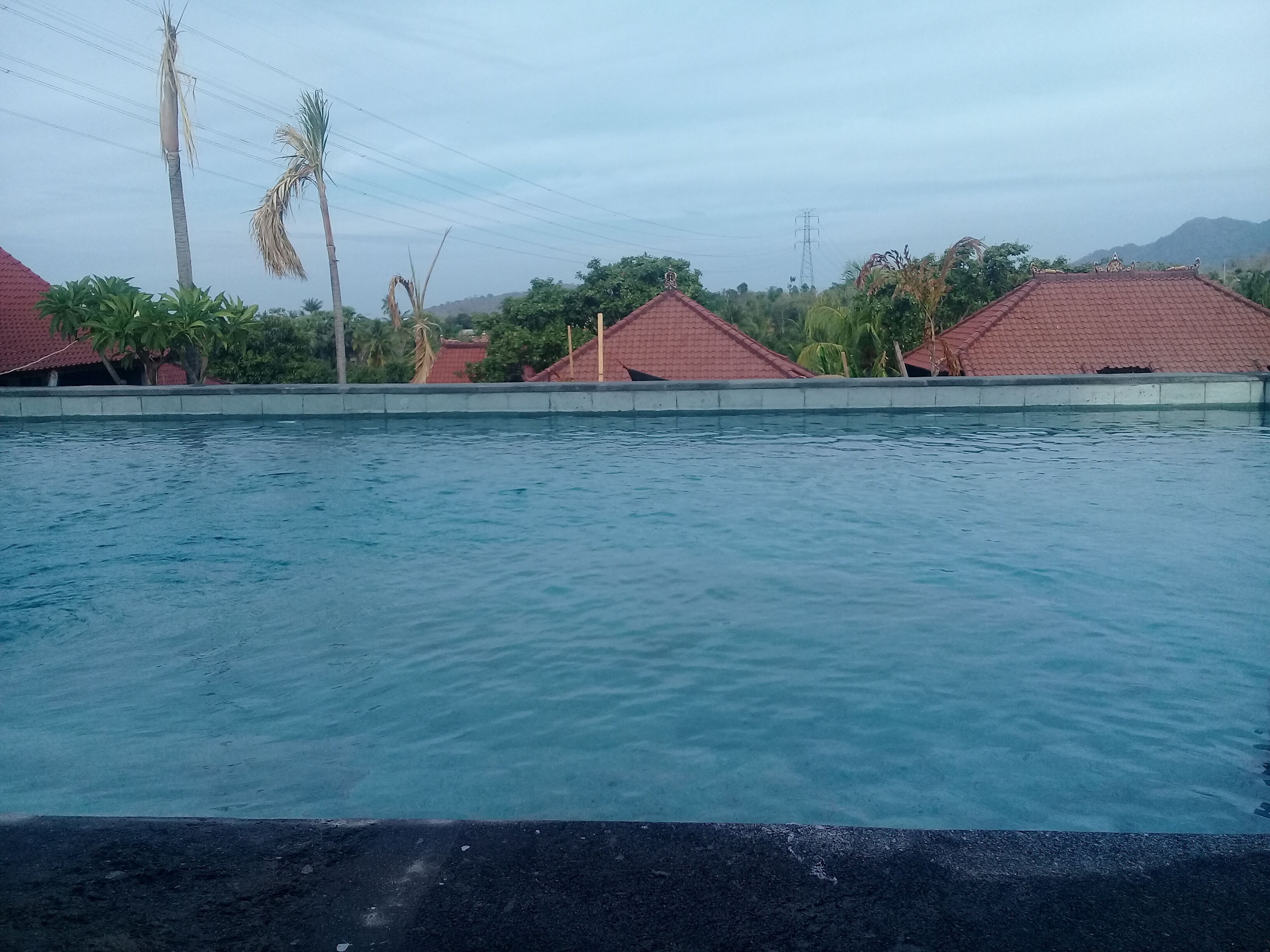 Une piscine avec, en arrière-plan, des bâtiments aux toits rouges.