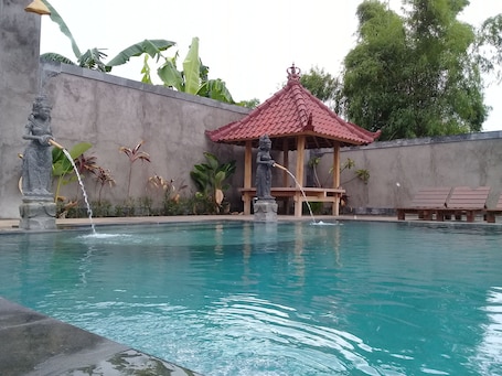 Una piscina al aire libre, sillones reclinables de piscina