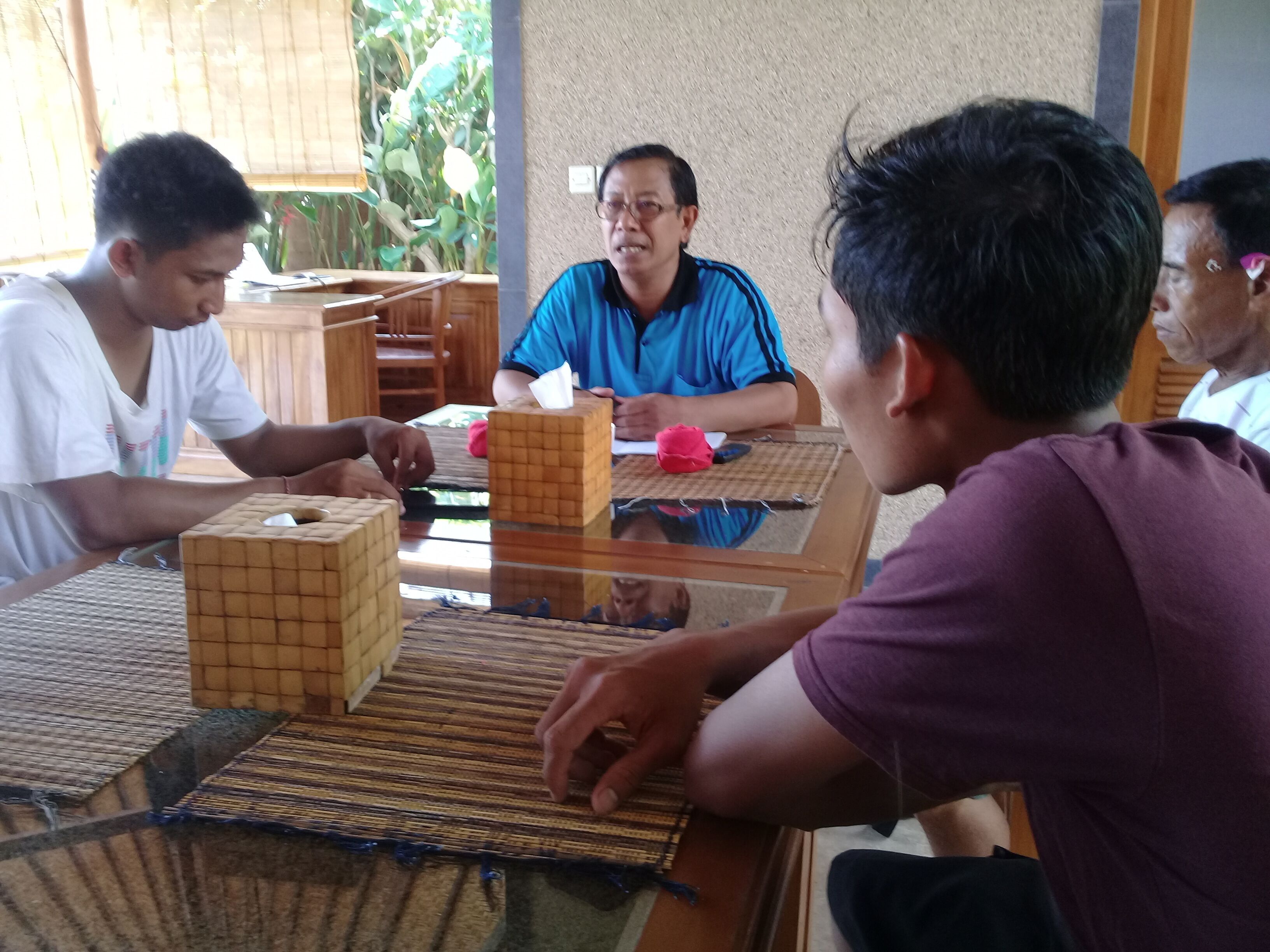 Eine Gruppe Menschen spielt ein Spiel an einem Tisch mit Glasplatte.