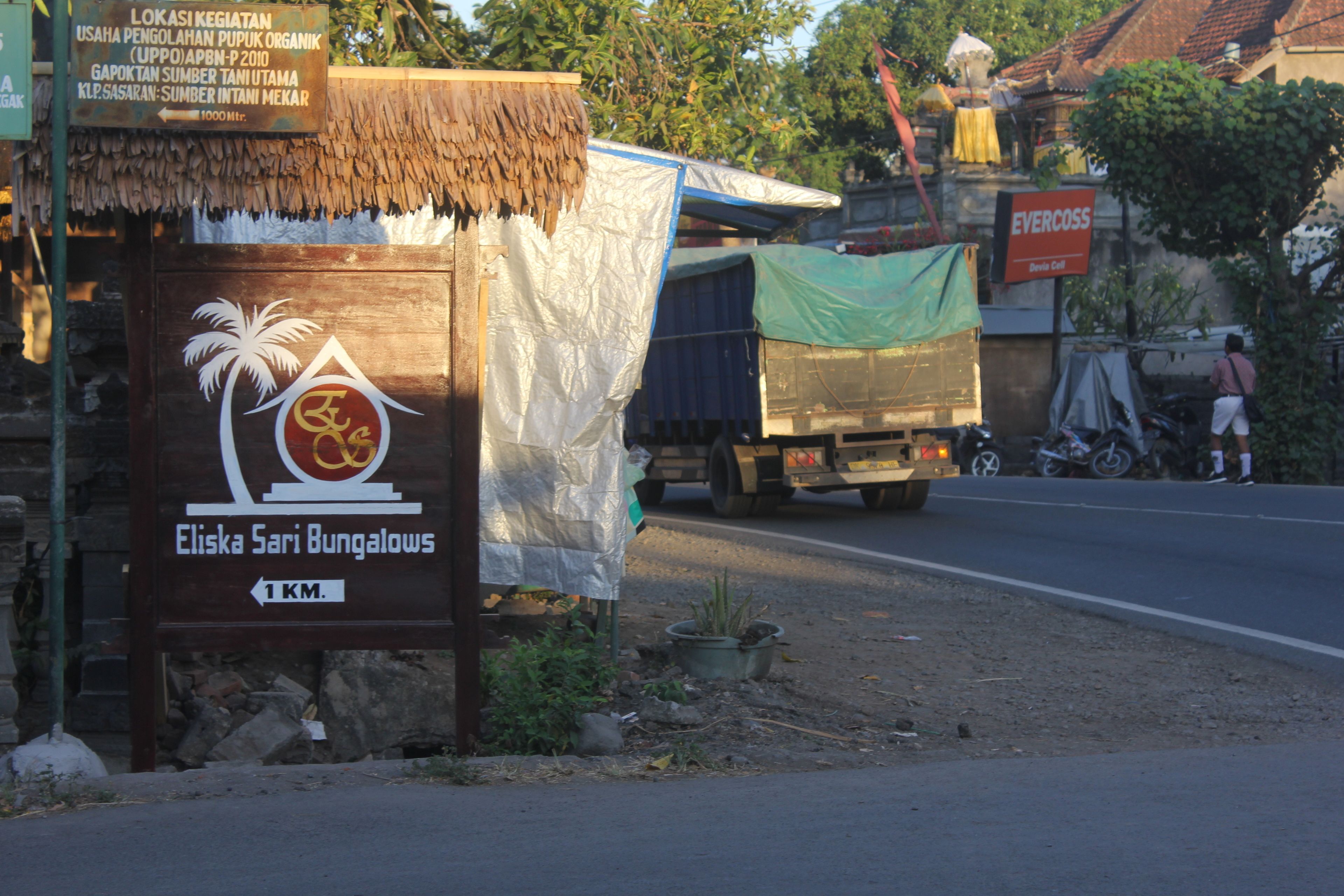 A sign for Eliska Sari Bungalows indicating it is 1 km away.