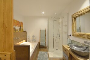 A bathroom with a bathtub, a large mirror, a shower, and a wooden vanity. - Holiday rental villa with swimming pool in Begur, Centre (Begur)
