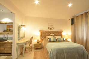 A bedroom with a bed, bedside lamps, a nightstand, a mirror, and a wooden headboard. - Holiday rental villa with swimming pool in Begur, Centre (Begur)