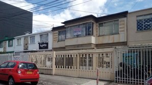 A building with a sign that reads "ARRIENDA EXPRESOS CULINAR" and a "GUAPO" sign. - Apartamento Amoblado El Dorado (Bogotá)