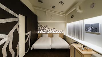 A modern hotel room with a large bed, a desk, and a view of the city.