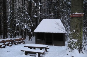 Eine schneebedeckte Hütte mit einem Schild, auf dem 'Baiplatzhütte' steht.