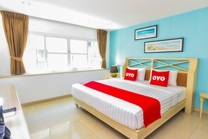 A hotel room with a bed, a desk, a lamp, and a window with curtains. - OYO 394 Nana Beach Cha Am (Cha-am)
