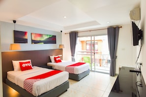 Une chambre d’hôtel avec deux lits, une télévision, un balcon avec des rideaux et des œuvres d’art accrochées au mur.