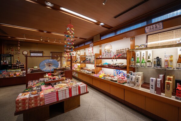 A traditional Japanese store with wooden interiors, shelves stocked with snacks, and a display of packaged goods.