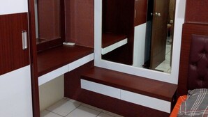 A bedroom with a wardrobe, a mirror, and a bed. - Kemang View Apartment (Bekasi)