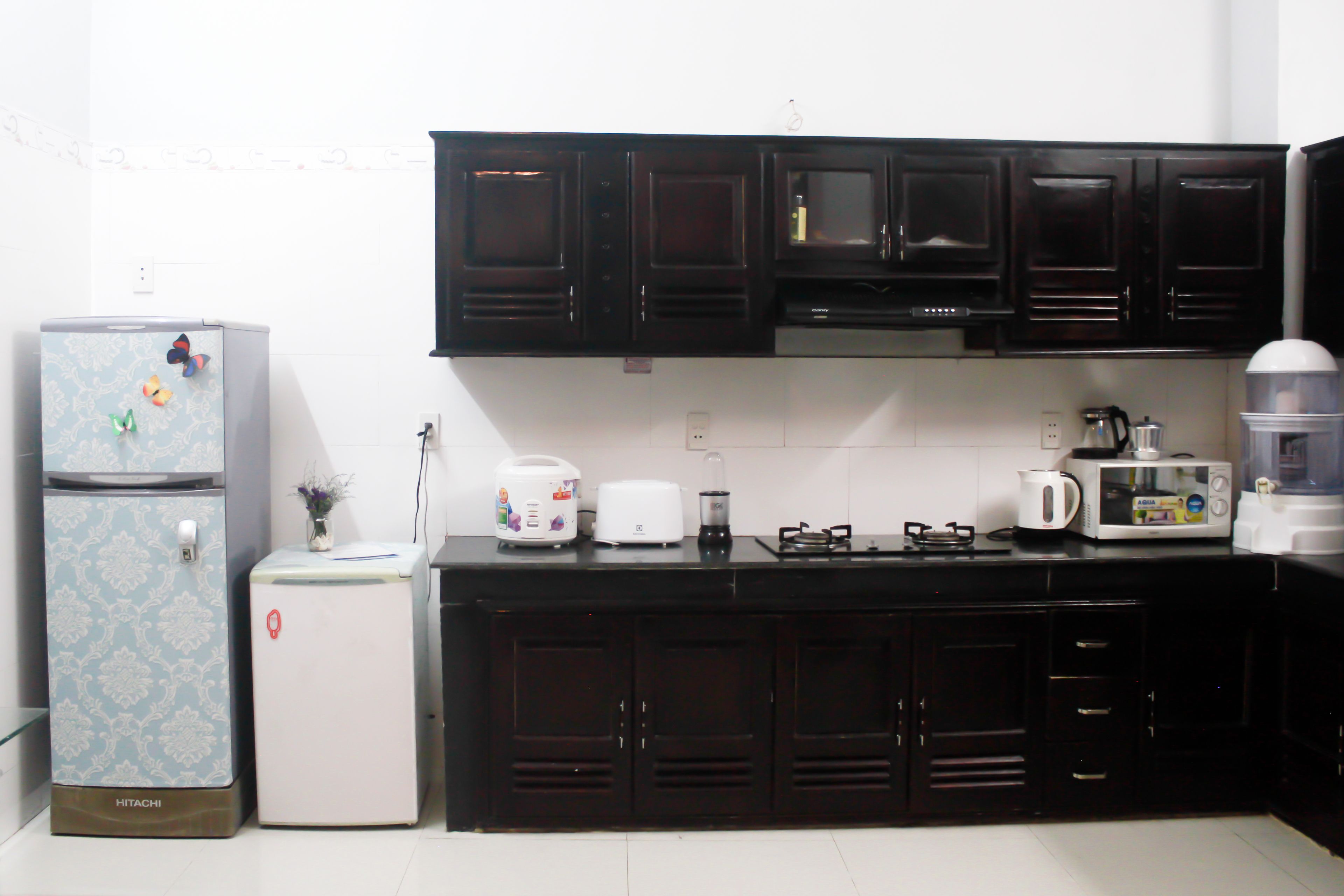 A compact kitchen with a refrigerator, microwave, toaster, and a coffee maker.
