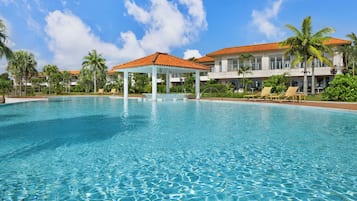 Een seizoensgebonden buitenzwembad, ligstoelen bij het zwembad