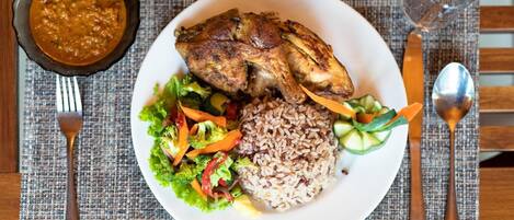 Une assiette composée de poulet grillé, de riz et d’une salade en accompagnement.