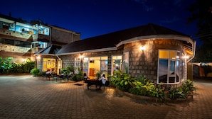 Un restaurante con terraza, paredes de piedra y vistas al cielo nocturno.