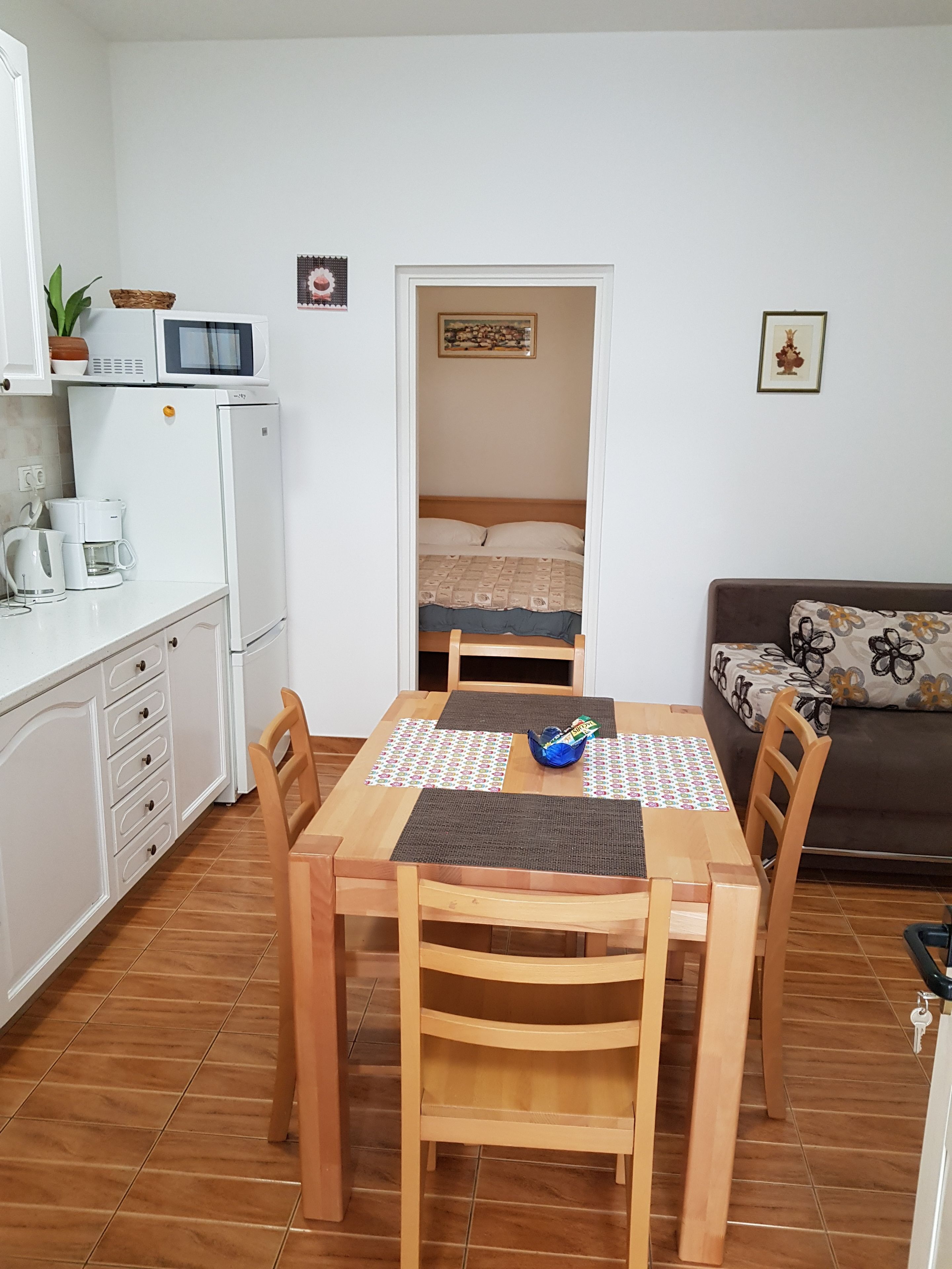 A compact living space with a kitchenette, a dining area, and a bedroom.