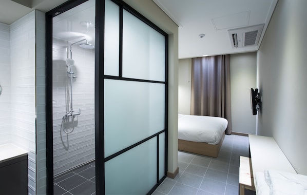 A modern hotel room with a shower, a bed, a bedside table, and a curtain. - Hotel Millhaus Shinchon (Seoul)