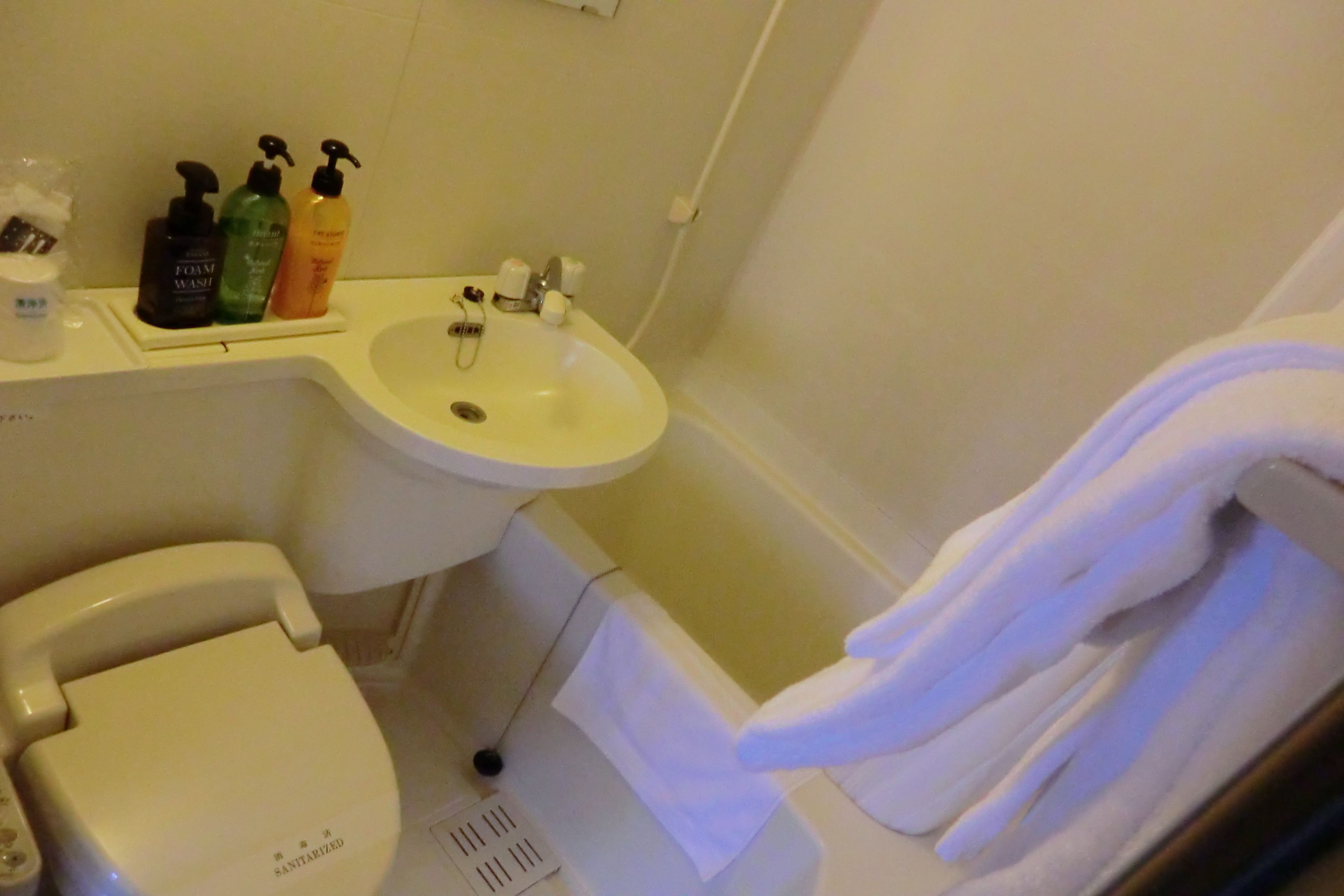 A bathroom with a toilet, sink, and bathtub.
