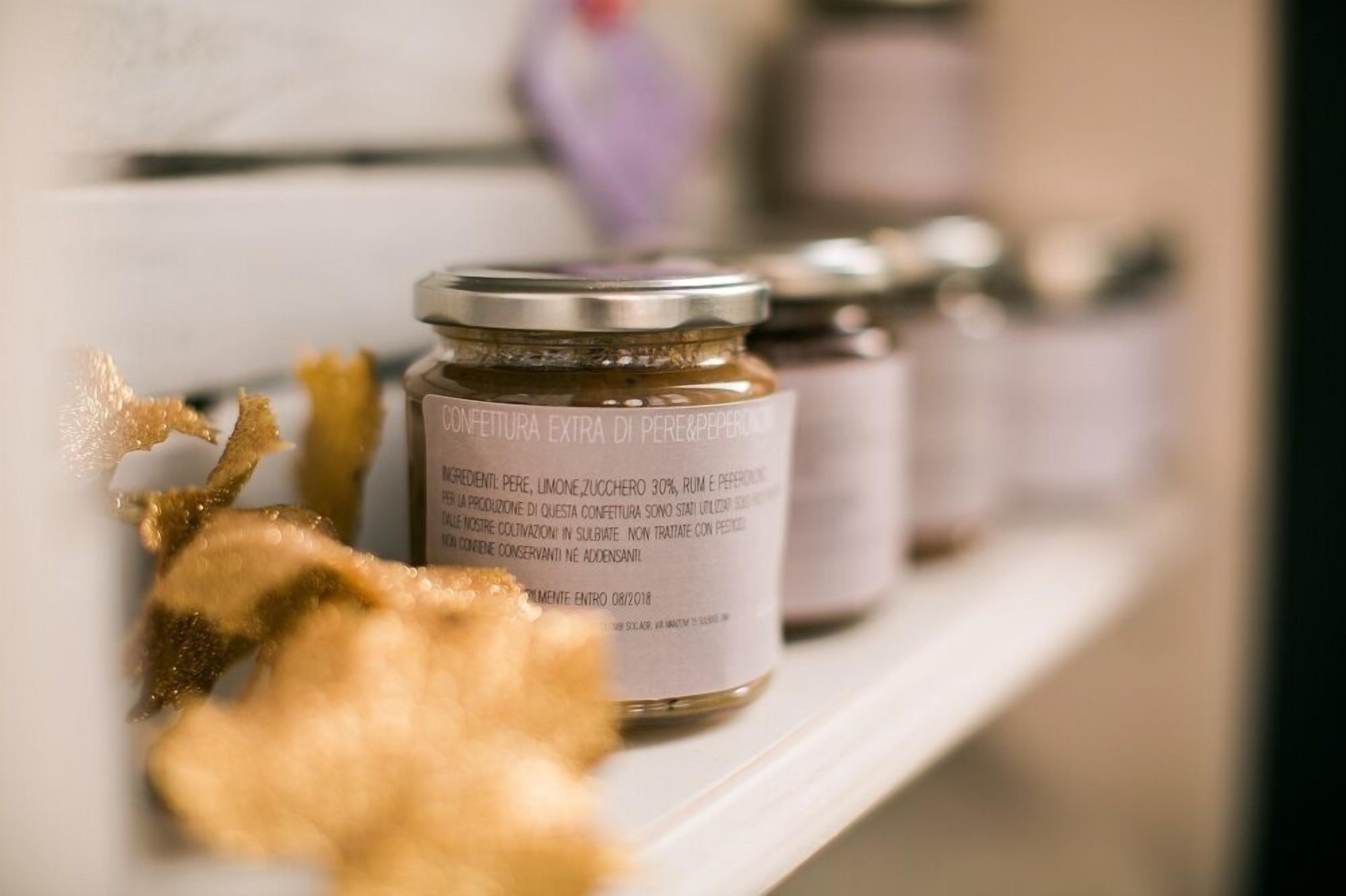 Three jars of extra virgin olive oil on a shelf.
