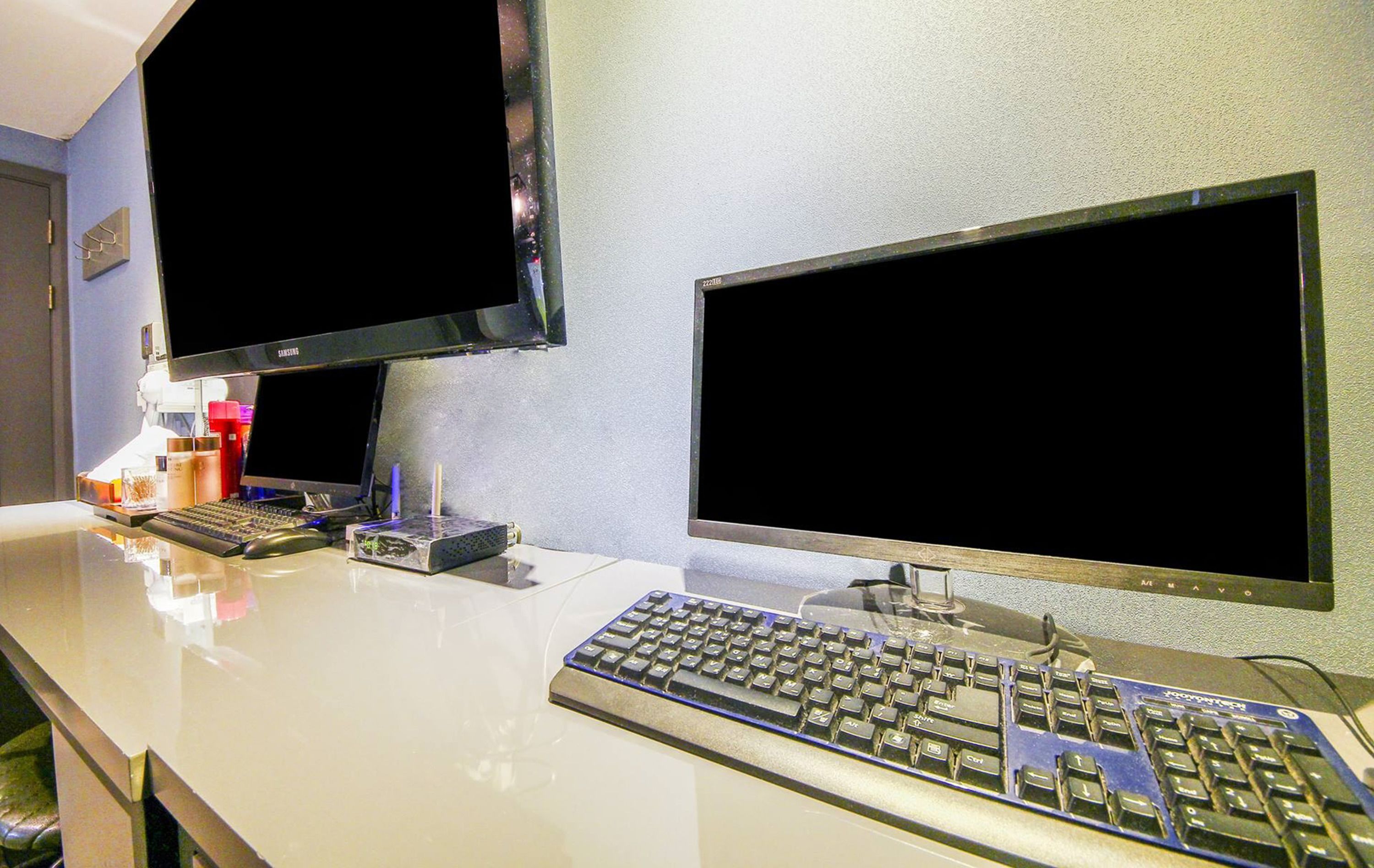 A modern office setup with two monitors, a keyboard, and a mouse on a white desk.