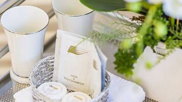 Un plateau contenant un emballage de shampoing pour les cheveux et le corps, une bougie blanche et une bougie en verre.