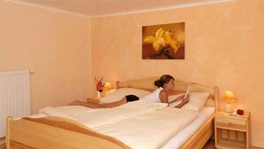 Ein Schlafzimmer mit einem großen Bett, einem Nachttisch mit Lampe und einem Blumenbild an der Wand.