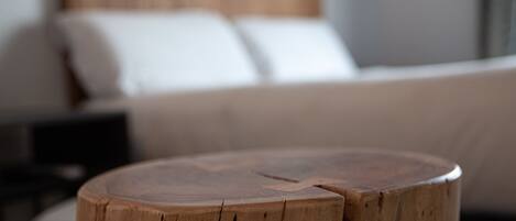 A round wooden table in a hotel room with a bed in the background.