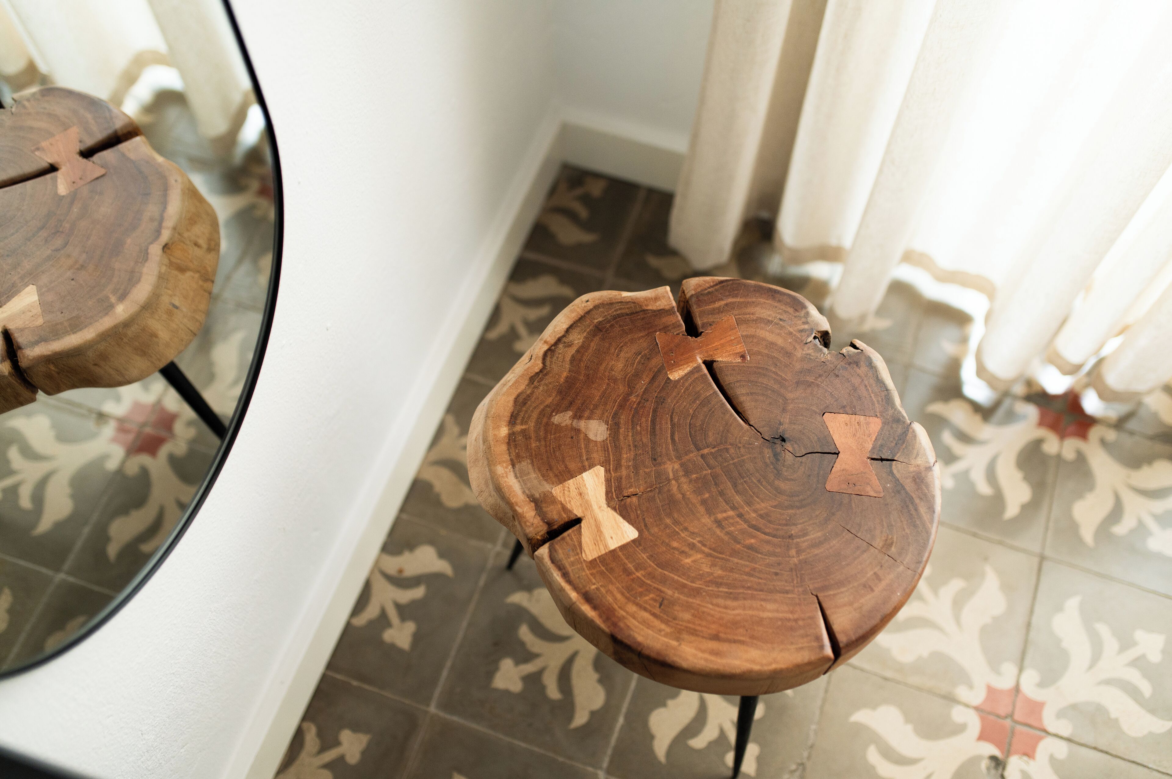 A round wooden stool with a natural wood finish and a visible crack.