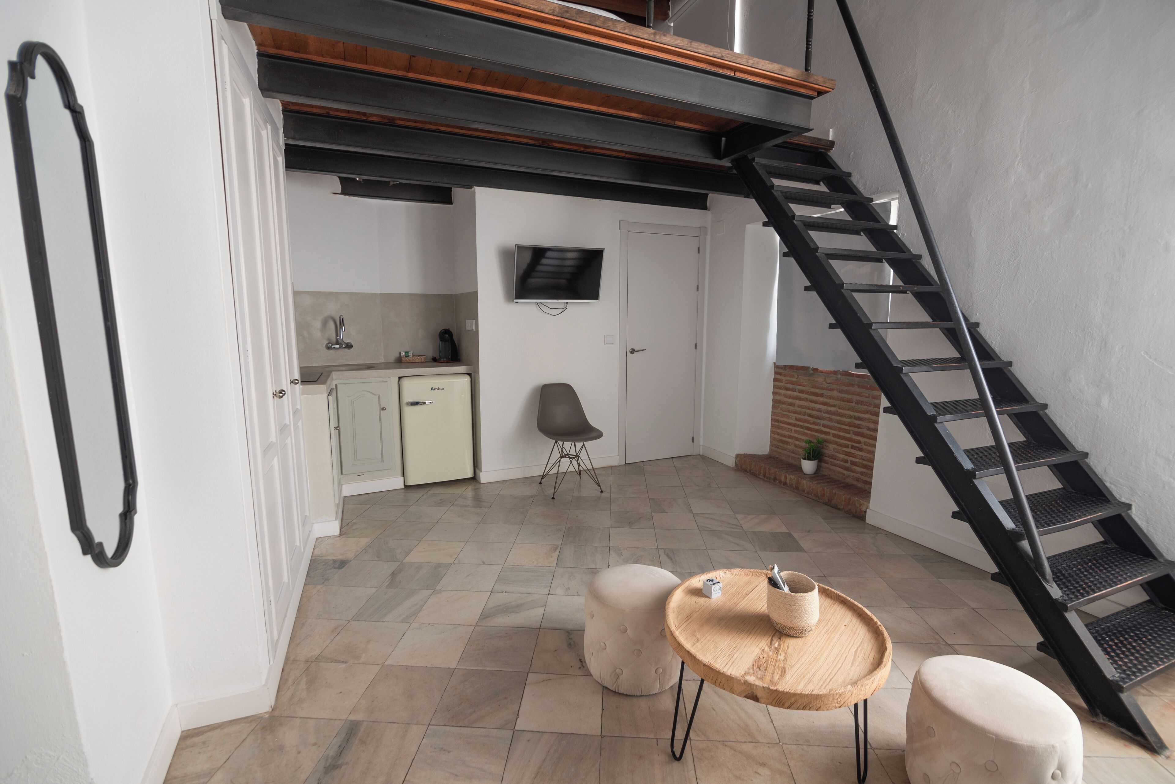 A modern interior with a kitchen, dining area, and a staircase.