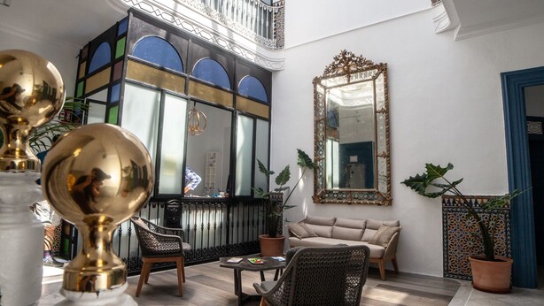 A spacious interior with a high ceiling, a balcony, and a large mirror. - Siglo XIX (Tarifa)