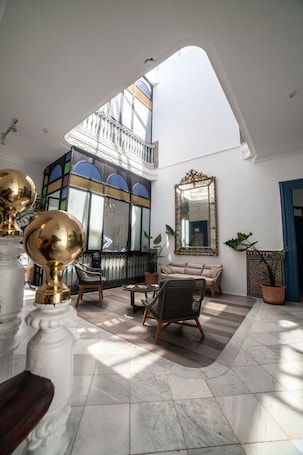 A spacious interior with a high ceiling, a balcony, and a large mirror.
