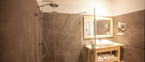 Une salle de bain moderne avec une douche à parois de verre, un meuble-lavabo en bois et un miroir au-dessus du lavabo.