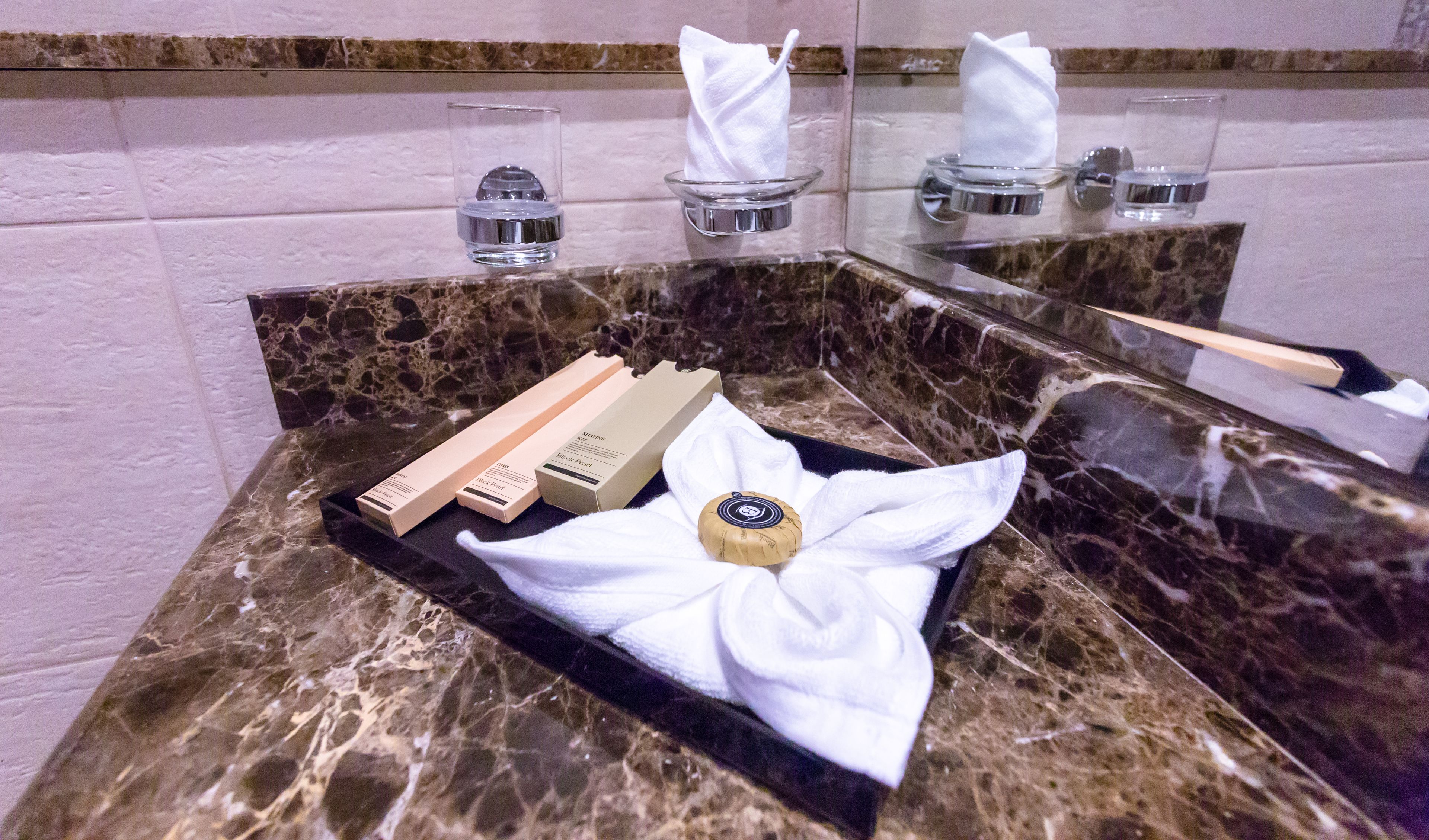 Ein Waschtisch aus Marmor mit Toilettenartikeln, Taschentüchern und einer Seife.