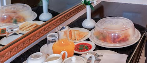 A breakfast buffet setup with various food items and beverages on a tray.