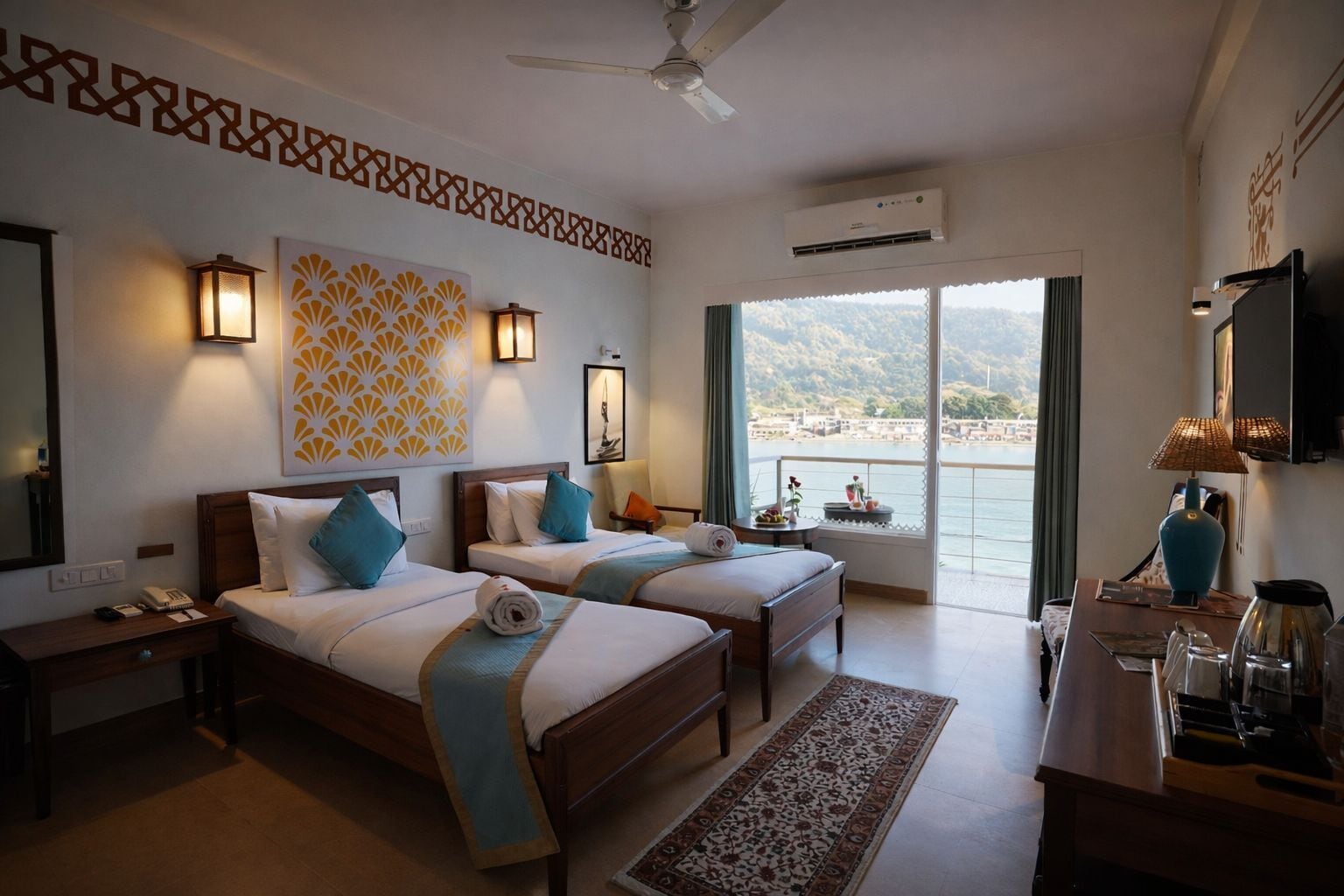 Habitación de hotel con dos camas, un escritorio, una silla, un televisor y un balcón con vista al mar.