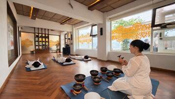 Un estudio de yoga con pisos de madera, ventanas amplias y un ambiente tranquilo.