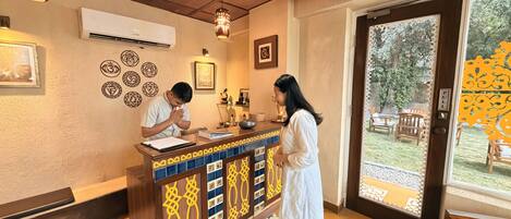 A reception desk with a patterned design, a wooden ceiling, and a view of the outdoors.