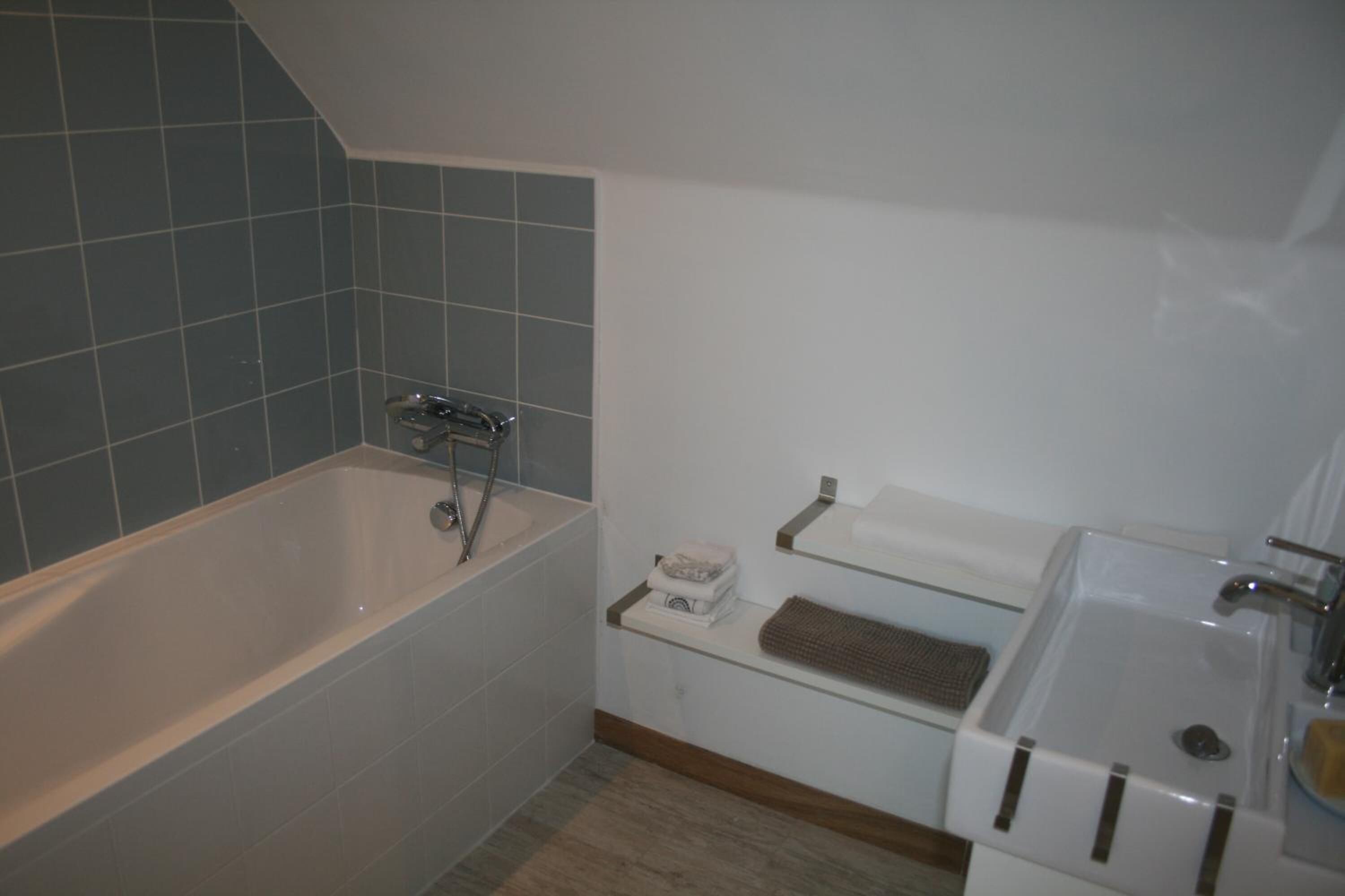 Un baño con una bañera, un lavamanos y un perchero para toallas.